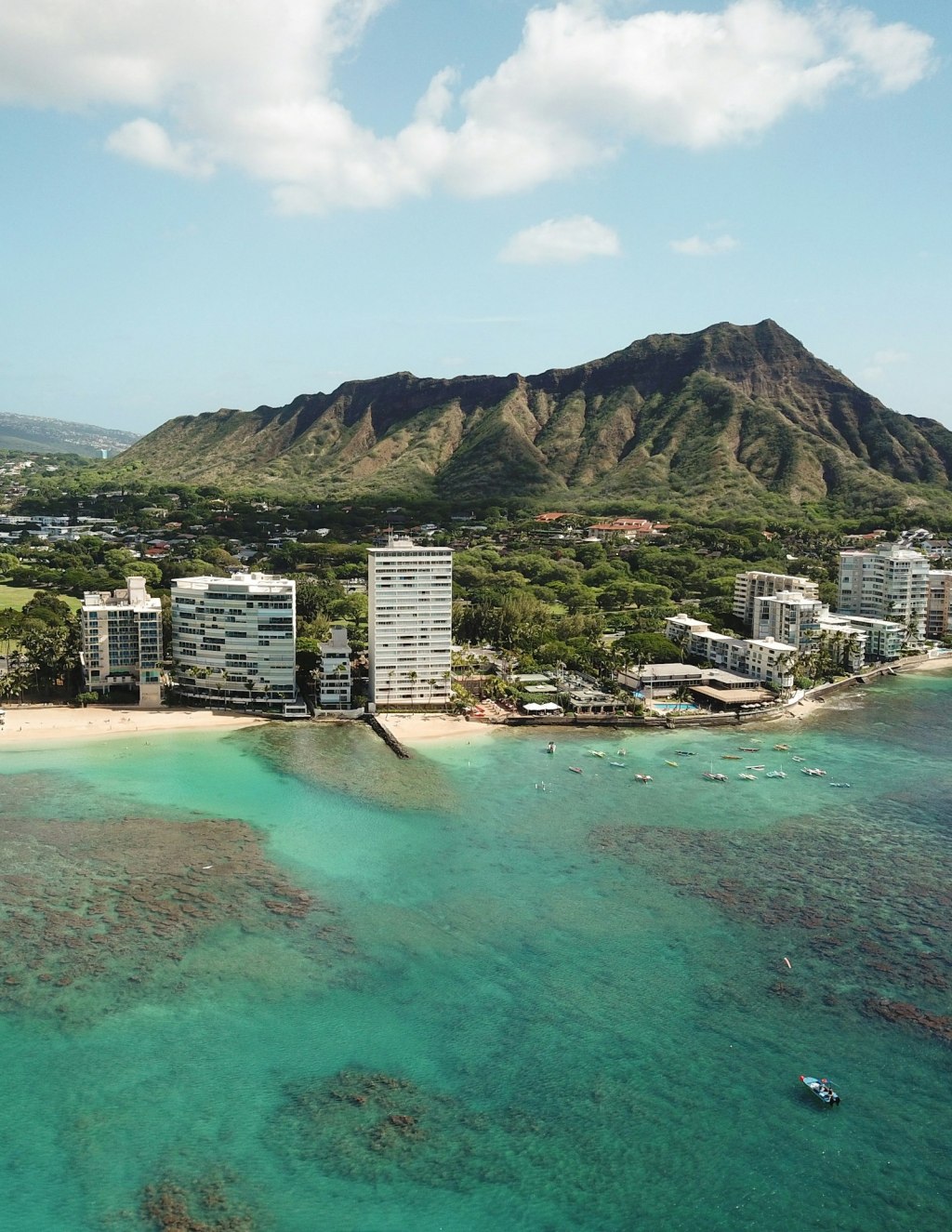 Aerial view of Honolulu high-rise buildings with mountains in the background