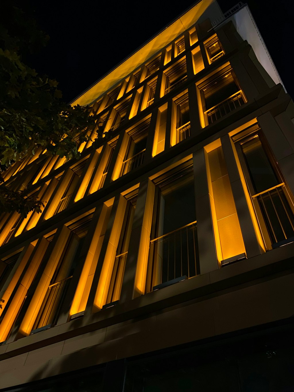 Low-angle view of a lighted multi-story building at night