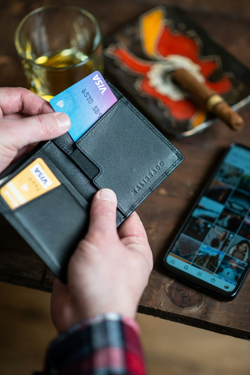 A black leather bifold wallet held open in a person's hand