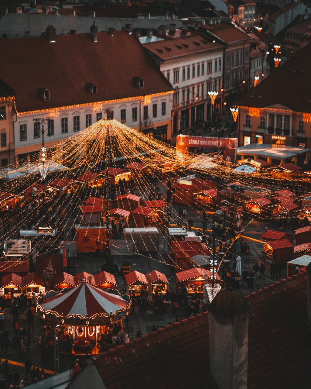 Aerial view of a busy European Christmas market lit up at night