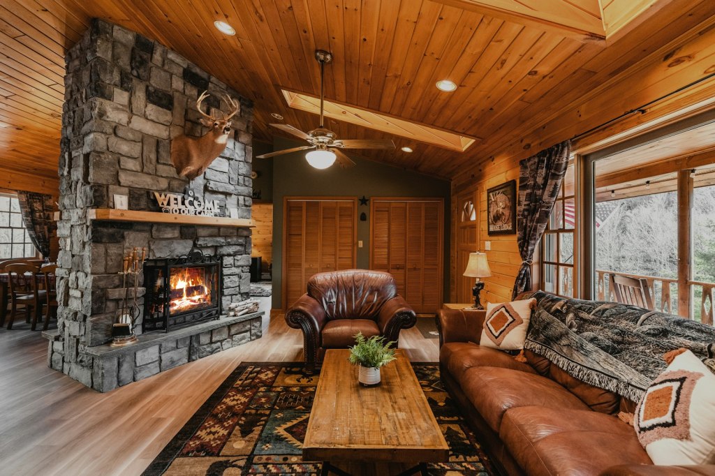 Cozy cabin-style vacation rental living room with a fireplace and comfortable furniture