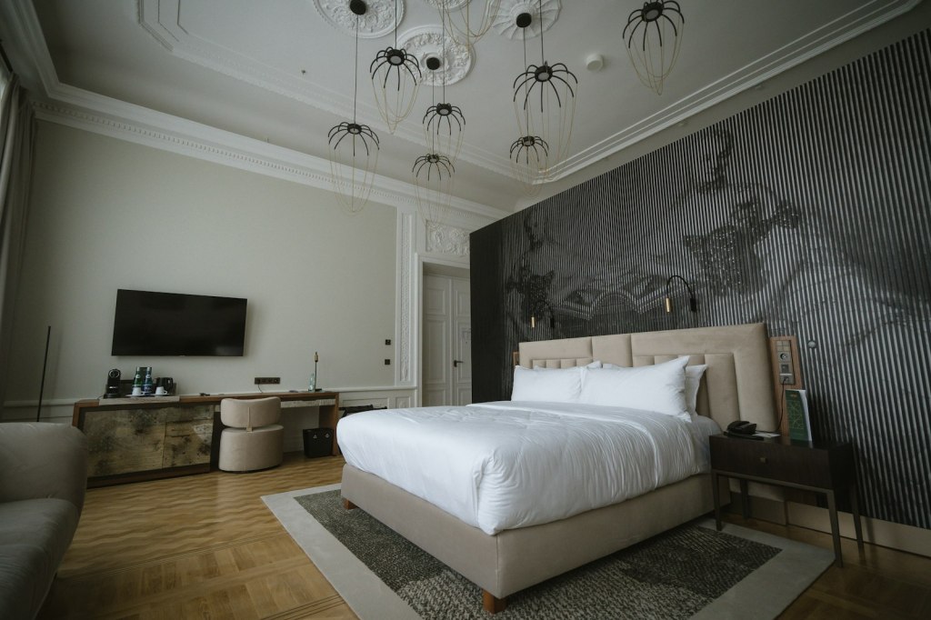 Modern hotel bedroom with a made bed and pendant lights