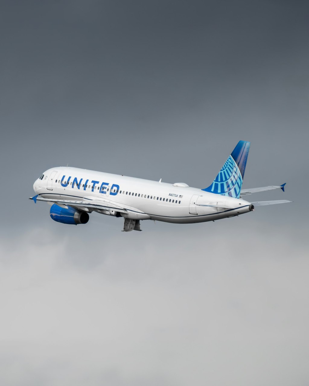 A United Airlines jet flying in a blue sky