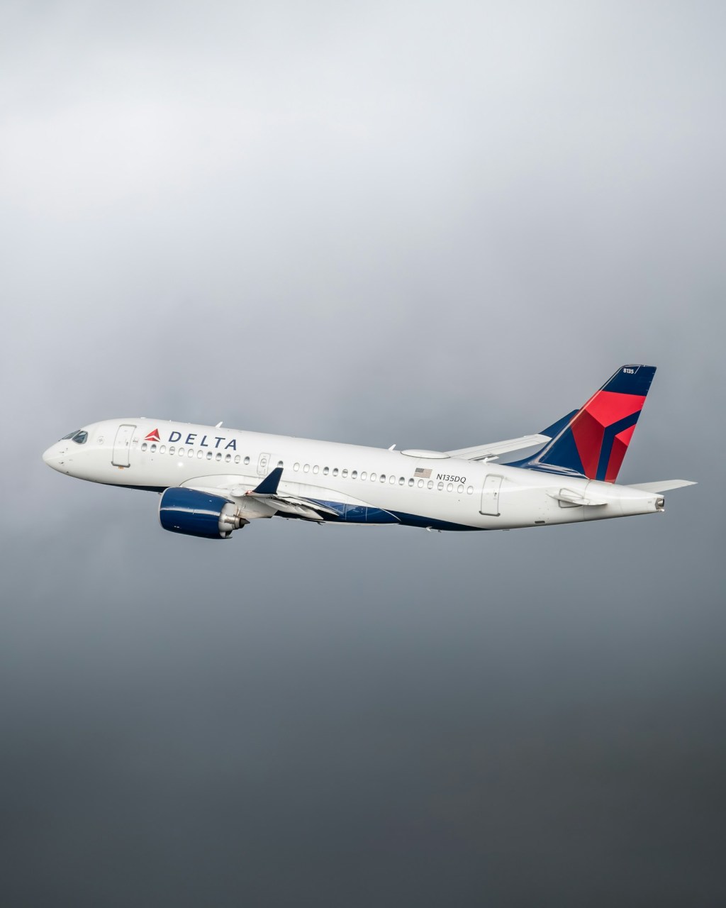 A Delta Air Lines airplane flying in a cloudy sky