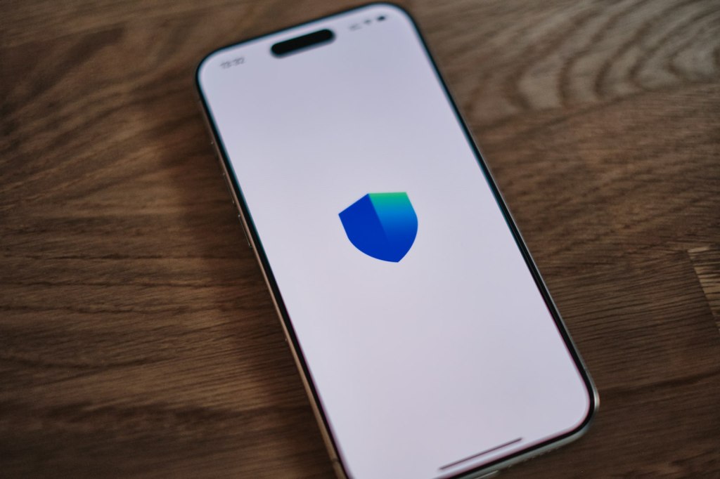 A smartphone showing a security shield symbol on its screen