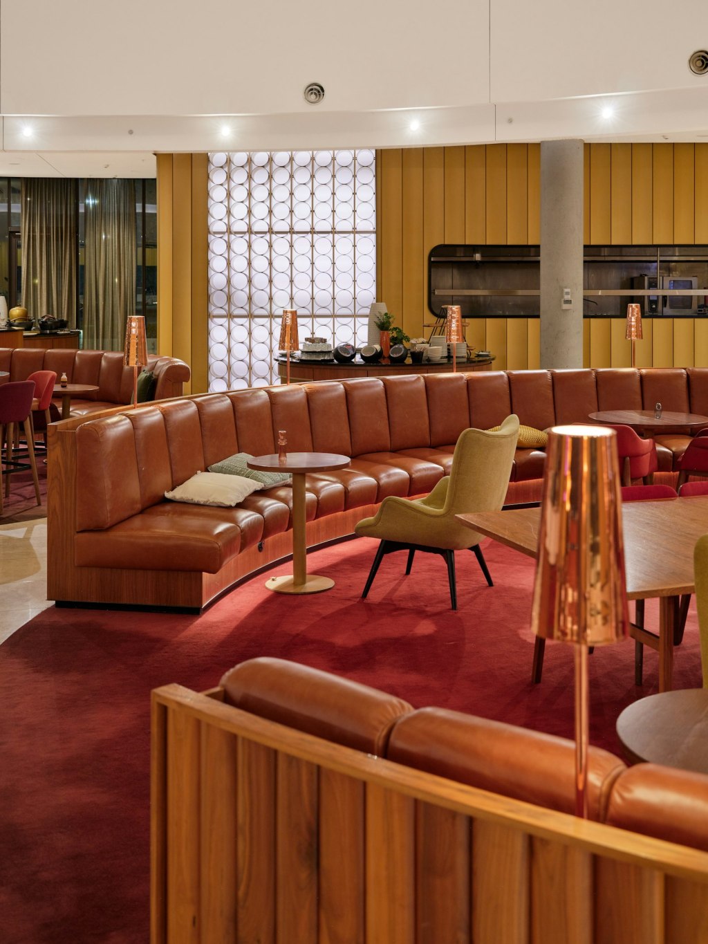 Modern airport lounge with curved leather seating and warm lighting
