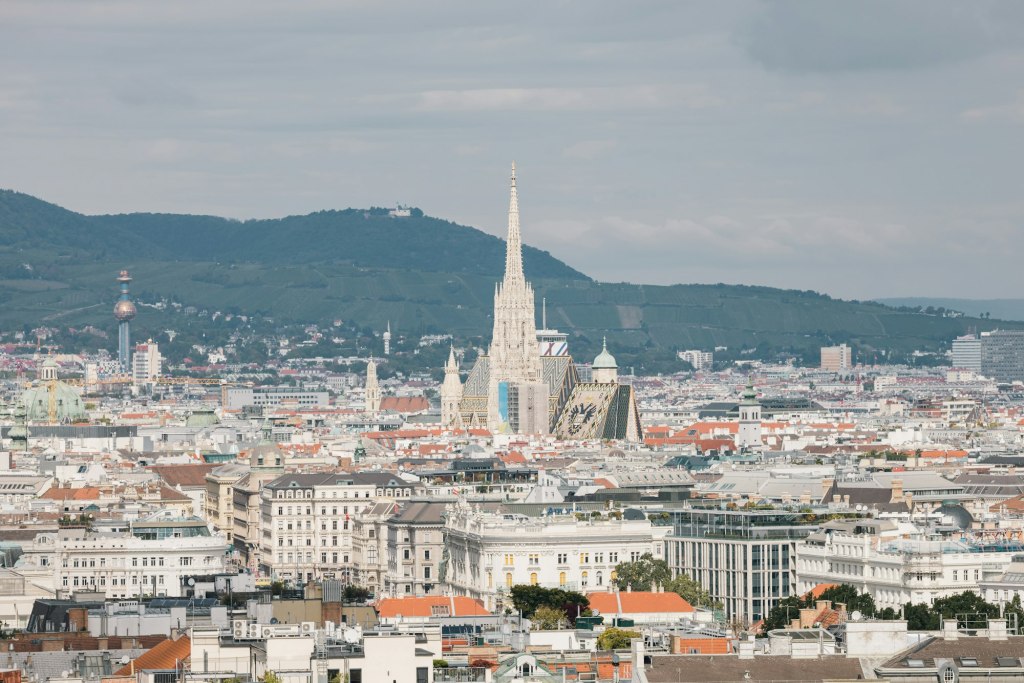 Vienna rooftops with the spire of St. Stephen's Cathedral rising over the city center and hills beyond